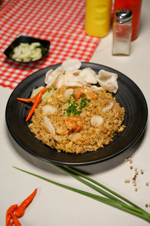 Fried rice with prawns and vegetables in a black plateの写真素材