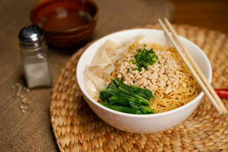 Chinese noodle with minced pork and vegetables in bowl on wooden tableの写真素材