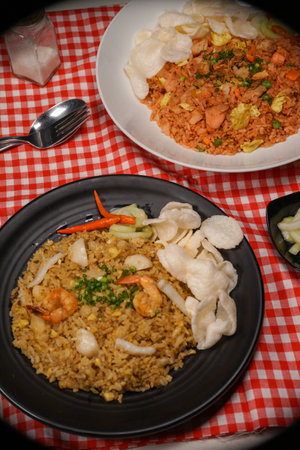 Fried rice with shrimps and vegetables in a black plateの写真素材