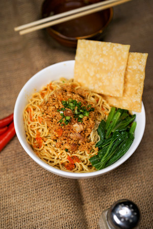Instant noodles in a bowl with chopsticks and chopsticks on jute backgroundの写真素材