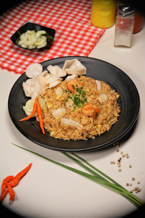 Fried rice with shrimp in a black plate on the table.の写真素材