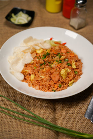 Fried rice with pork and vegetables in white plate on wooden tableの写真素材