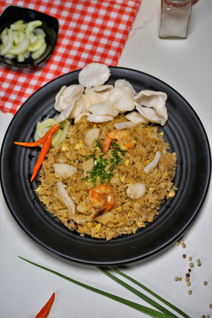 Fried rice with prawns in black plate on the tableの写真素材
