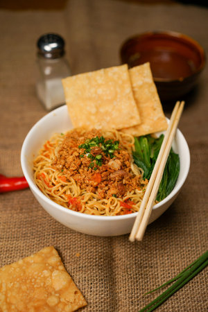 japanese spicy instant noodle with chopsticks on wood backgroundの写真素材