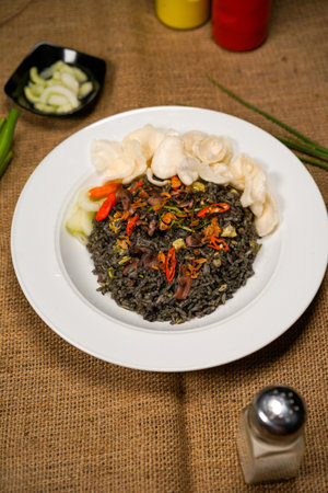 Rice with meat and vegetables in a white plate on burlap. squid fried riceの写真素材