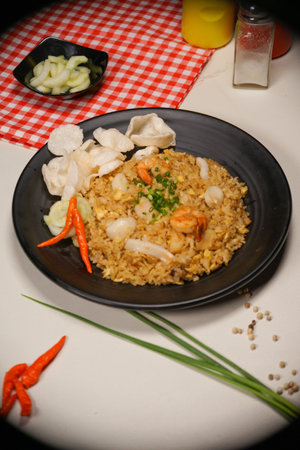 fried rice with shrimp and dumpling in black plate on tableの写真素材
