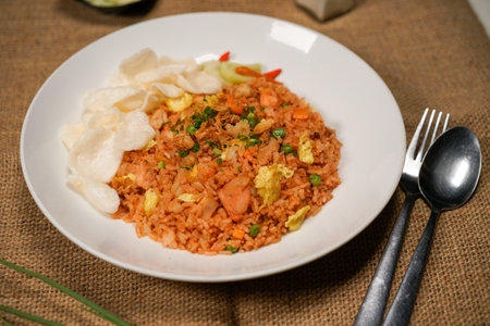 Fried rice with pork and vegetable on white plate with spoon and forkの写真素材
