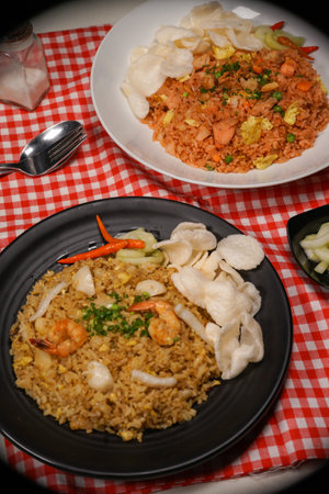 Fried rice with shrimps and vegetables on a black plateの写真素材
