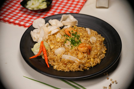 fried rice with shrimp and dumpling in black plate on tableの写真素材