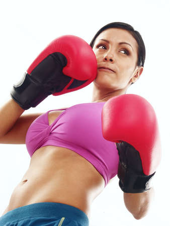 Young woman wearing boxing gloves on white backgroundの写真素材