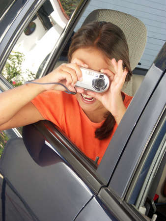 Little hispanic girl taking a picture from a car windowの写真素材