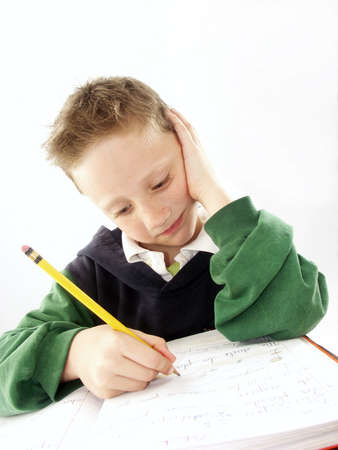 Little school boy doing his homeworkの写真素材