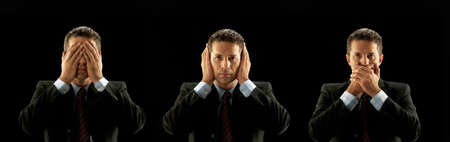 Businessman covering his mouth, eyes and ears on black backgroundの写真素材
