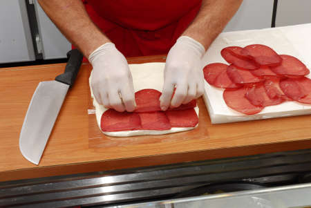 Preparing mozerella rolls with ham and saladの写真素材