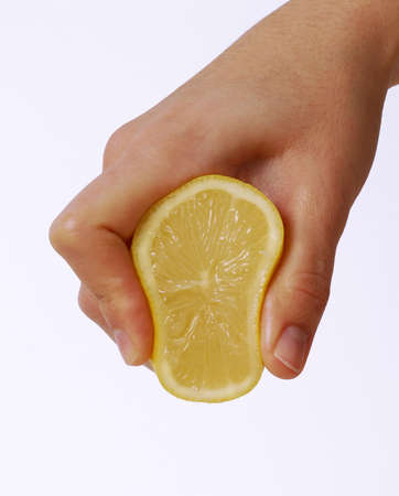 Human hand squeezing an orange on white の写真素材