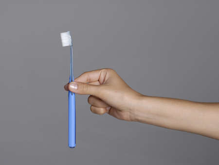 Human hand holding a toothbrush