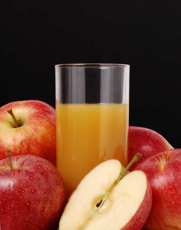 A glass of fruit juice surrounded by apples の写真素材