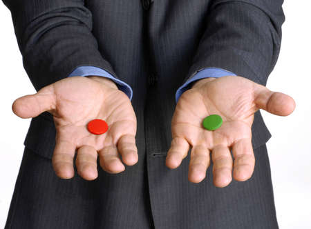 Man in suit offering two different colored buttonsの写真素材