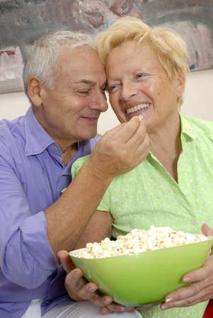 Happy senior couple enjoying popcornの写真素材