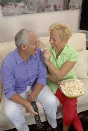 Happy senior couple enjoying popcornの写真素材