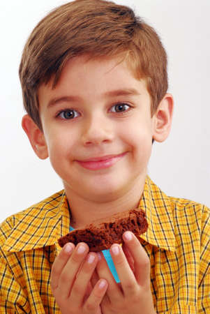Happy little kid eating chocolate brownie