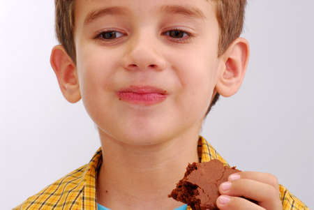 Happy little kid eating chocolate brownieの写真素材
