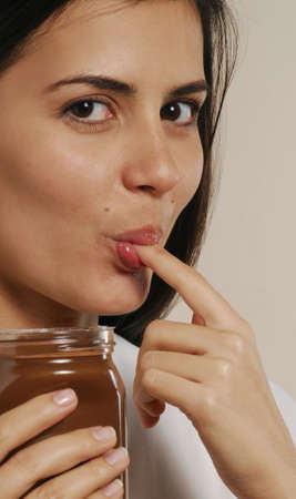 Beautiful woman with jar of chocolate sauce