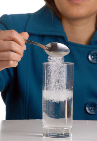 Woman pouring sugar into a glassの写真素材