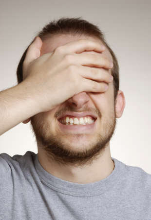 Young man with hand on faceの写真素材