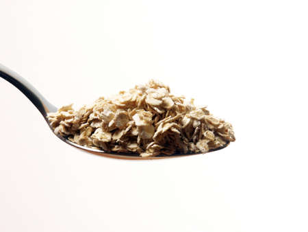 A teaspoon of cereal oat on white background 