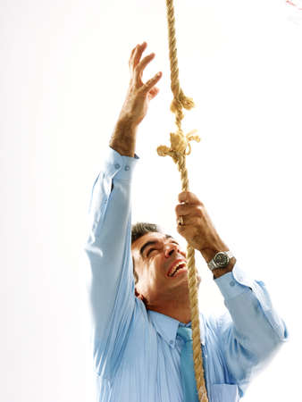 Man climbing a breaking ropeの写真素材