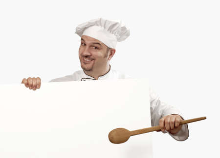 Chef is holding a white cardboard and wooden spoonの写真素材