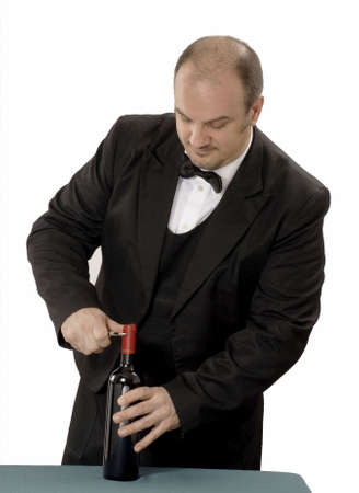 Young sommelier is trying to open the red wine bottle の写真素材