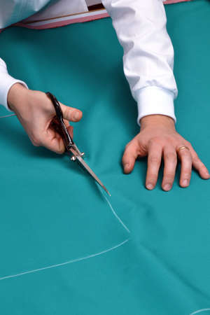 A tailor cutting fabric
