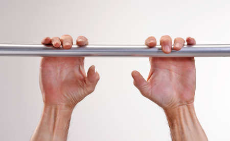 Hands holding onto a metal bar