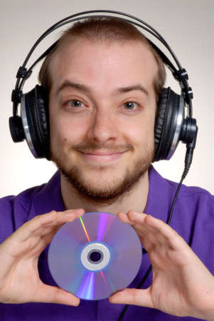 Portrait of a man with headphones and a CD