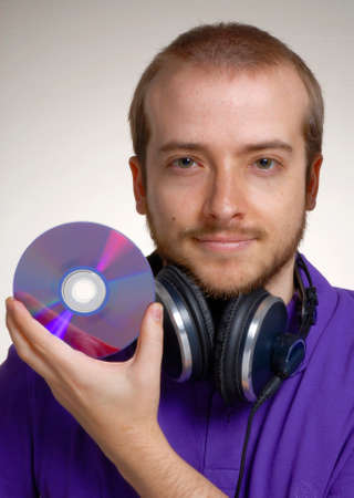Portrait of a man with headphones and a CDの写真素材