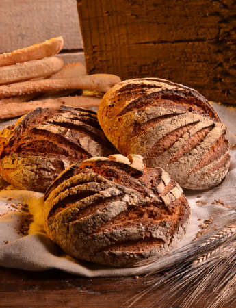 Rustic bread and wheat on an old vintage wood table and chest.