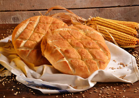 Rustic bread and wheat on an old vintage wood table and chest.の写真素材
