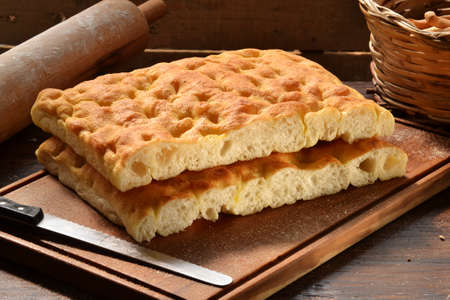 Foccacia Italian bread on rustic wood table and ingredients.Rustic bread and corn on an old vintage wood table.の写真素材