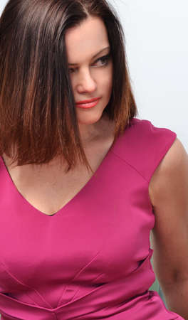 Caucasian fashion woman posing wearing pink dress.