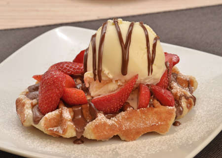 Strawberry waffle and vanilla ice cream with chocolate syrupの写真素材