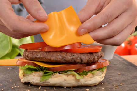 Cheddar cheese on burger.Preparing and making hamburger.の写真素材