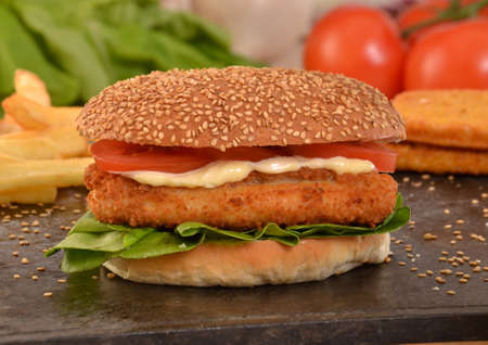 Chicken burger on grill stone and ingredients.の写真素材
