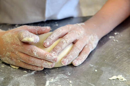 Cook preparing pizza dough.
