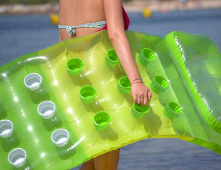 walking to to the beach holding an air mattress,inflate bed.の写真素材