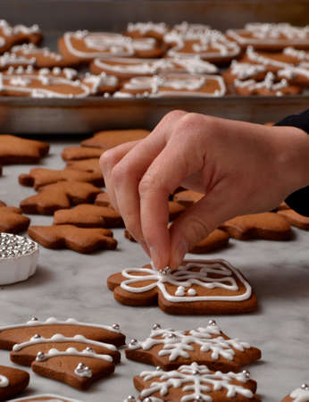 Pastry chef hands preparing christmas cookies holding a vanilla cream cone.の写真素材
