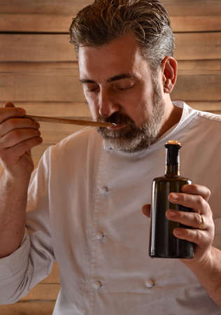 Businessman chef holding extra virgin olive oil bottle