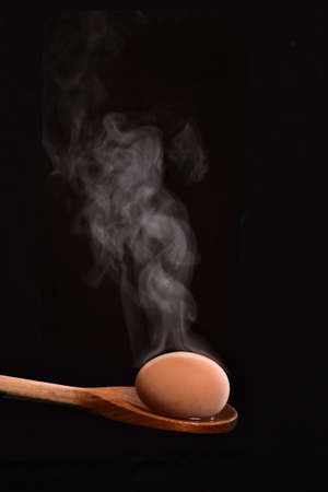 Boiled egg on wood spoon.の写真素材