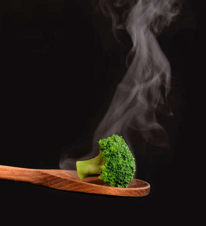 Hot broccoli on fork.On black background.の写真素材